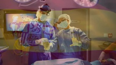 Animation of spanish national flag waving over surgeons discussing in operating room during surgery. Digital composite, multiple exposure, healthcare, medical, teamwork, patriotism and identity.