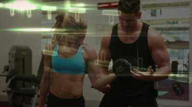 Spor salonundaki beyaz çift üzerinde veri işleme ve DNA ipliği animasyonu. Küresel spor ve dijital arayüz kavramı dijital olarak oluşturulmuş video.