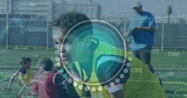 Animation of scope scanning and data processing over biracial boy football player on pitch. Sports, competition and data processing concept digitally generated video.