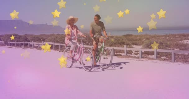 在海滩上 多颗金色的星光映衬着一对老夫妇骑自行车在一起 踏板日意识概念 — 图库视频影像
