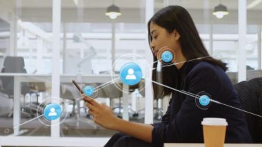 Akıllı telefon kullanan iki ırklı iş kadınının üzerindeki simgelerle olan bağlantıların animasyonu. Küresel iş, bağlantılar ve dijital arayüz kavramı dijital olarak oluşturulmuş video.