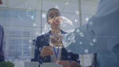 Animation of globe with data processing and icons over diverse business people. Global business, computing and digital interface concept digitally generated video.