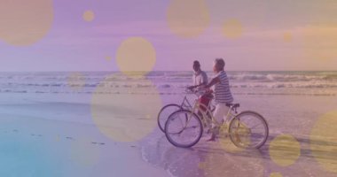 Sahilde birlikte yürüyen bisikletli Afrikalı Amerikalı son sınıf öğrencilerine karşı sarı ışık noktaları. pedal gün farkındalığı kavramı