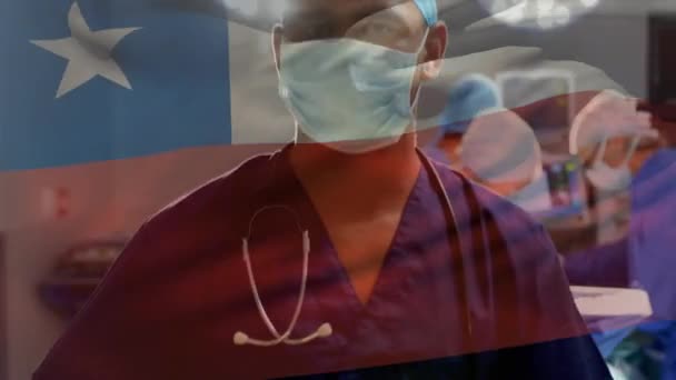 手术室内儿童国旗在高加索男外科医生肖像上的动画效果 数字合成 多重暴露 医疗保健 爱国主义和身份认同概念 — 图库视频影像