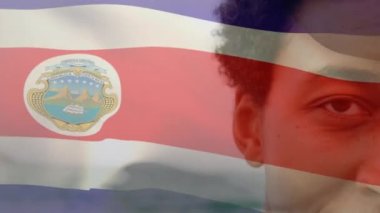 Kosta Rika bayrağının animasyonu. Sahildeki Afrikalı Amerikalı adam yerine. Ulusal bayraklar, vatanseverlik ve dijital olarak üretilen tatil konsepti.