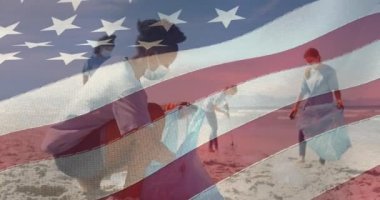 Composite video of american flag against group of diverse female volunteers cleaning the beach. environmental protection concept