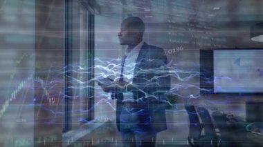Animation of financial data processing over african american man using tablet. Global business, finances and data processing concept digitally generated video.