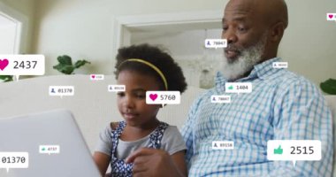 Afro-Amerikan adam ve torununun dizüstü bilgisayar kullanarak giderek artan sayıdaki ikonların animasyonu. Küresel sosyal medya ve dijital arayüz kavramı dijital olarak oluşturulmuş video.