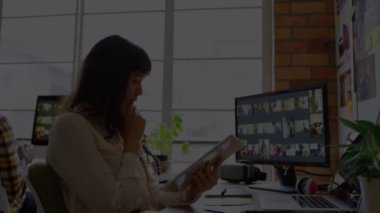 Animation of light trails over caucasian businesswoman using tablet. Global business, computing and digital interface concept digitally generated video.