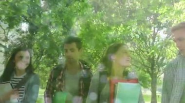 Composite video of flowing water against group of diverse college students walking in the garden. education concept