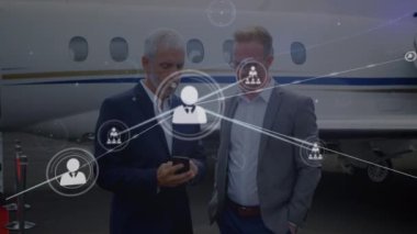 Havaalanında akıllı telefon kullanan iki beyaz iş adamının profili simgelerinin oluşturulması. Küresel ağ ve iş teknolojisi kavramı