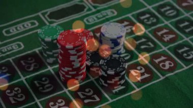 Animation of spots of light over close up of a stack of casino poker chips on a table. Casino and gambling concept