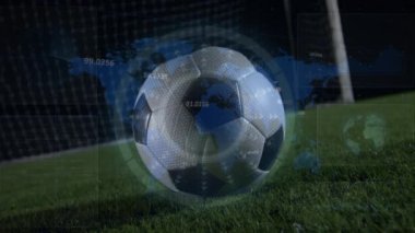 Animation of circle and map over low section of soccer player kicking towards net at night. Digital composite, multiple exposure, globalization, practicing, soccer, competition and sport concept.