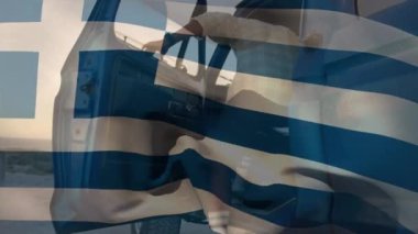 Animation of greece flag waving over african american man getting in pick-up truck at beach. Road trip, digital composite, multiple exposure, vacation, travel, patriotism and identity concept.