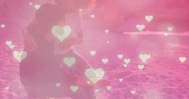 Çeşitli çiftlerin üzerine düşen kalplerin animasyonu. Küresel yaşam tarzı, boş zaman ve dijital arayüz kavramı dijital olarak oluşturulmuş video.