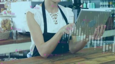 Animation of financial graphs over happy caucasian female seller using tablet. Business, finance, economy and working with technology concept digitally generated video.