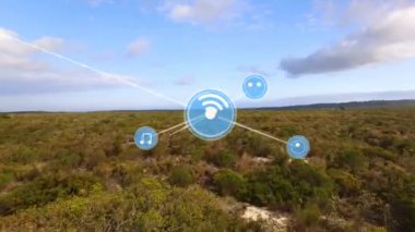 Animation of network of communication icons exchanging data over field and cloudy blue sky. Global communication, music and data sharing concept digitally generated video.