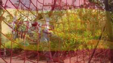 Animation of flag of spain over african american man during obstacle race training. national sports, activity and patriotism concept digitally generated video.