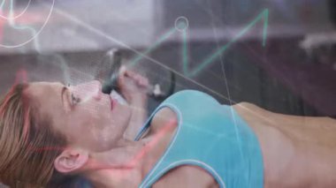 Animation of statistics and data processing over fit caucasian woman exercising. Sports, exercise, fitness and data processing concept digitally generated video.