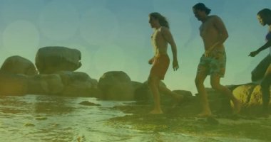 Denize koşan bir grup erkek arkadaşın üzerinde parlayan ışıkların animasyonu. Arkadaşlık, yaz ve tatil konsepti dijital olarak oluşturulmuş video.