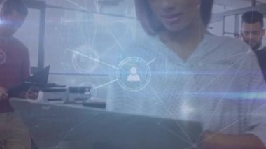 Animation of profile icon connecting dots, multiracial colleagues with laptops in modern office. Digital composite, multiple exposure, business, technology, connect the dots, networking.