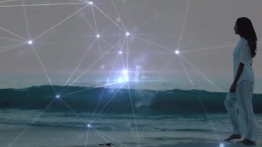 Sahilde yürüyen melez bir kadının üzerindeki ışık lekelerinin canlandırması. Küresel spor ve dijital arayüz kavramı dijital olarak oluşturulmuş video.