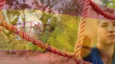 Animation of flag of spain over caucasian woman during obstacle race training. national sports, activity and patriotism concept digitally generated video.