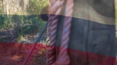 Animation of flag of russina over biracial boy during obstacle race training. national sports, activity and patriotism concept digitally generated video.