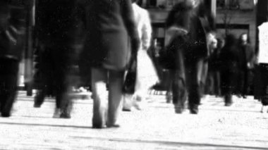 Animation of dots over blurred black and white walking people. City life and lifestyle concept concept digitally generated video.