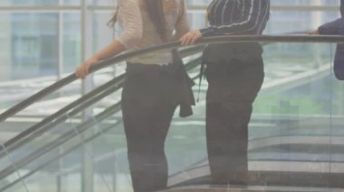 Farklı erkek ve kadın iş adamları şehir manzarası üzerinde yürüyen merdiven kullanıyor. İletişim, çeşitlilik, iş ve iş konsepti dijital olarak oluşturulmuş video.