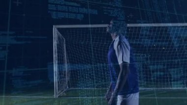 Animation of clock and data processing over african american male football player with ball on pitch. Sports, competition, computing and data processing concept digitally generated video.