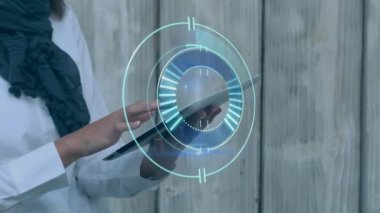 Animation of processing circle over hands of caucasian businesswoman using tablet. business, time, network and technology concept digitally generated video.