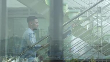 Dizüstü bilgisayarlı çeşitli erkek ve kadın iş arkadaşları merdivenlerde, şehir manzarası üzerinde konuşuyor. İletişim, çeşitlilik, iş ve iş konsepti dijital olarak oluşturulmuş video.