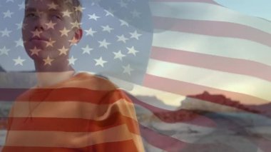 Gün batımında plajda dinlenen beyaz bir genç üzerinde Amerikan bayrağı sallama animasyonu. Dijital kompozit, çoklu pozlama, seyahat, tatil, eğlence, vatanseverlik ve kimlik konsepti.