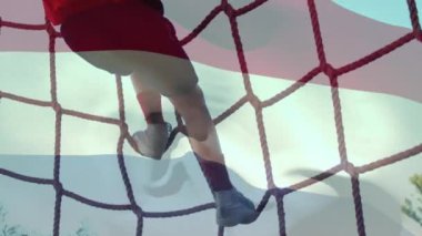 Animation of flag of netherlands over caucasian boy during obstacle race training. national sports, activity and patriotism concept digitally generated video.