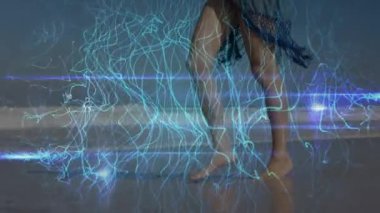 Animation of light trails over caucasian woman walking at beach. Global sport and digital interface concept digitally generated video.