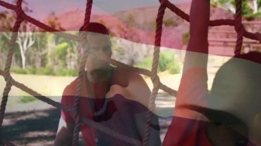 Animation of flag of netherlands over caucasian man and boy during obstacle race training. national sports, activity and patriotism concept digitally generated video.