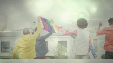 Diverse group of people holding rainbow flag while walking towards building. Unaltered, , community, unity, lgbtqia rights, lgbtqia culture, rainbow flag and gay pride symbol concept.