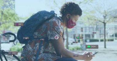 Animation of social media icons over african american woman with face mask using smartphone. Global covid 19 pandemic, social media, and digital interface concept digitally generated video.