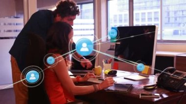 Animation of network of profile icons over diverse male and female colleagues discussing at office. Global networking and business technology concept