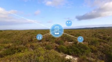 Animation of network of media icons exchanging data over field and cloudy blue sky. Global communication, music and data sharing concept digitally generated video.