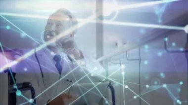 Animation of profile icons interconnecting with lines over male caucasian doctor using tablet pc. Digital composite , multiple exposure, network, technology, telecommunication, healthcare, medical.