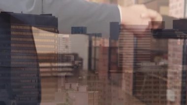 Businessman shaking hands with female lawyer holding law book, over cityscape. Communication, diversity, work and business concept digitally generated video.