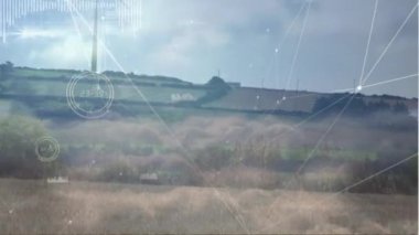 Animation of network of connections and data processing over spinning windmill against blue sky. Global networking and renewable energy technology concept