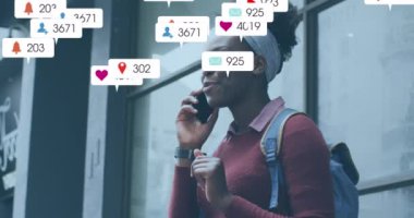 Animation of multiple social media icons over african american woman talking on smartphone outdoors. Social media networking and technology concept