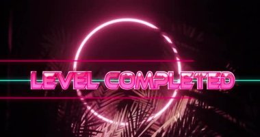 Animation of level completed text in shiny pink and ring in pink neon, over palm leaves on black. Game screen interface, competition and leisure retro future concept digitally generated video.