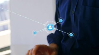 Animation of network of connections with people icons over caucasian businessman using tablet. Global connections, networks and business concept digitally generated video.