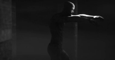 Image of scary zombie mummy walking in dark crypt room, in black and white. Halloween fear, horror and suspense concept digitally generated image.