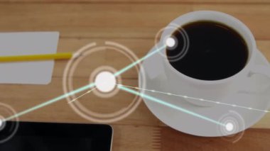 Animation of network of connections over close up of office equipment on wooden table. Global networking and business technology concept