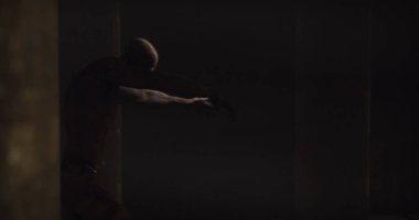 Image of scary zombie mummy walking around in dark crypt room. Halloween fear, horror and suspense concept digitally generated image.